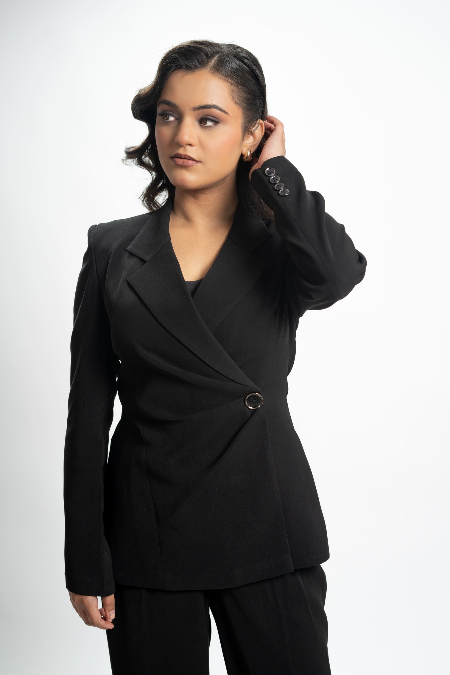 Woman wearing a black suit against a white background